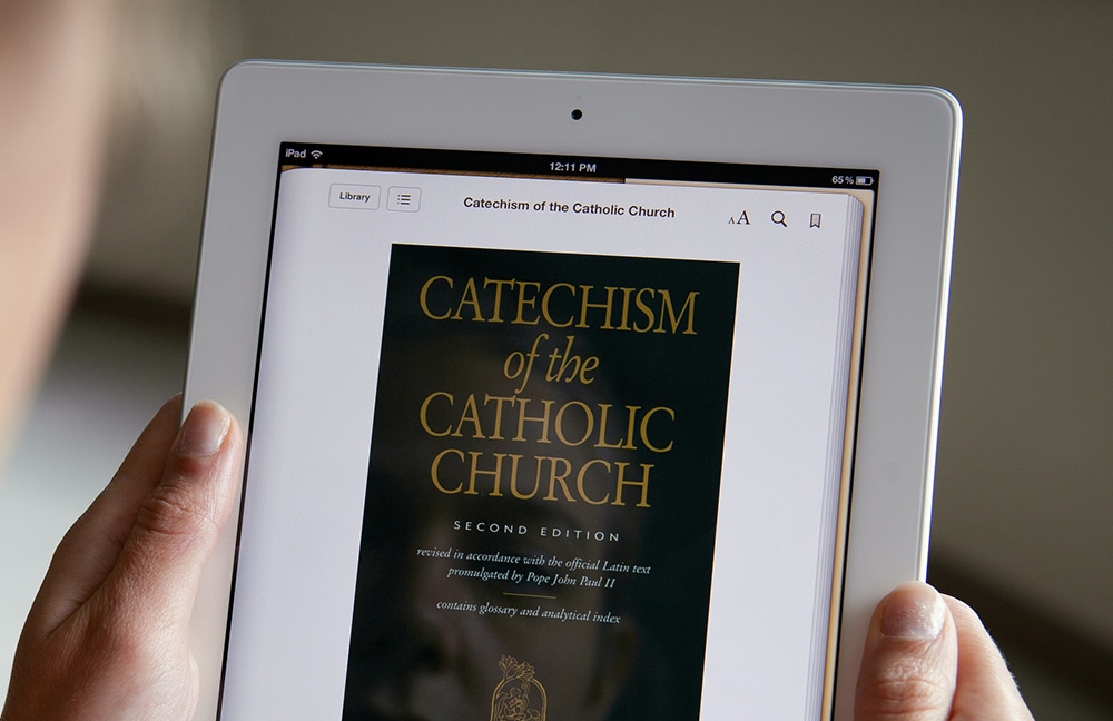 WOMAN DISPLAYS E-BOOK VERSION OF CATHOLIC CATECHISM