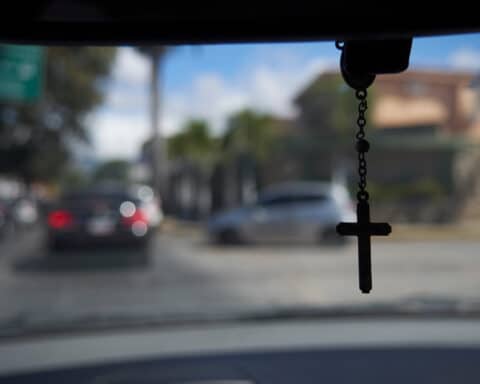 cross hanging from rear view mirror