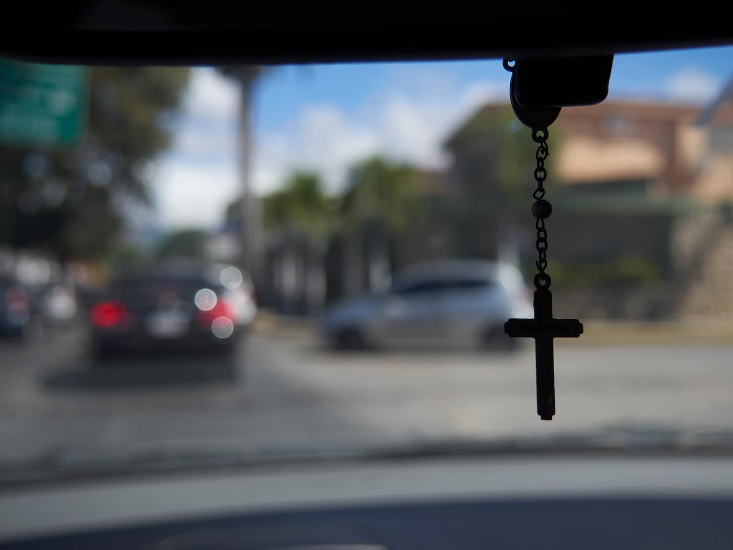 cross hanging from rear view mirror