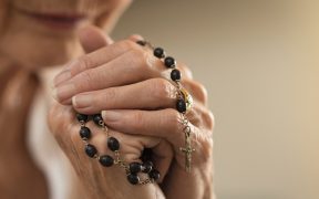 Elderly woman praying rosary