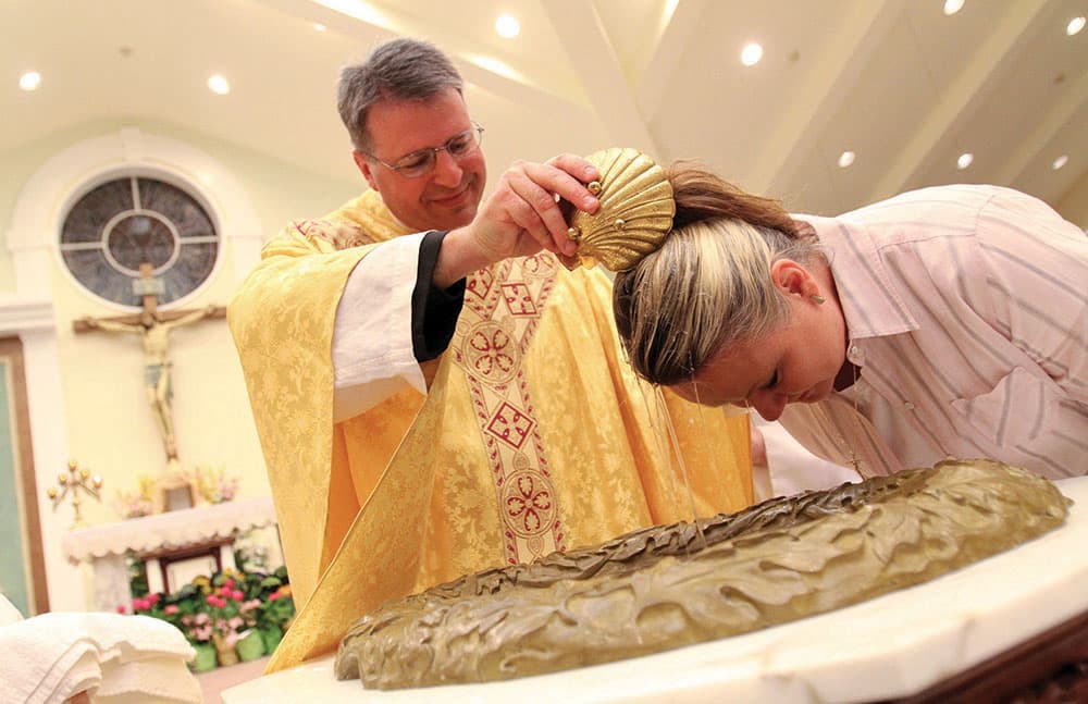 PRIEST BAPTIZES CATECHUMEN DURING EASTER VIGIL AT NEW YORK CHURCH