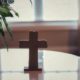 A cross on a glass table-concept bless our home