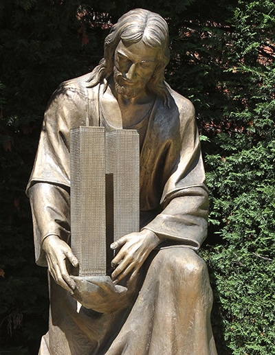 A sculpture of Jesus embracing the twin towers