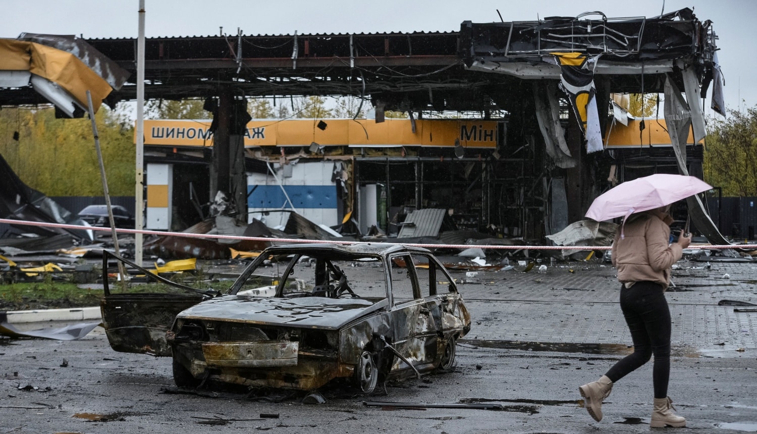 A woman passes by a gas station destroyed by a Russian military strike Oct. 26, 2022, as Russia's attack on Ukraine continues. (CNS photo/Mykola Synelnykov, Reuters)