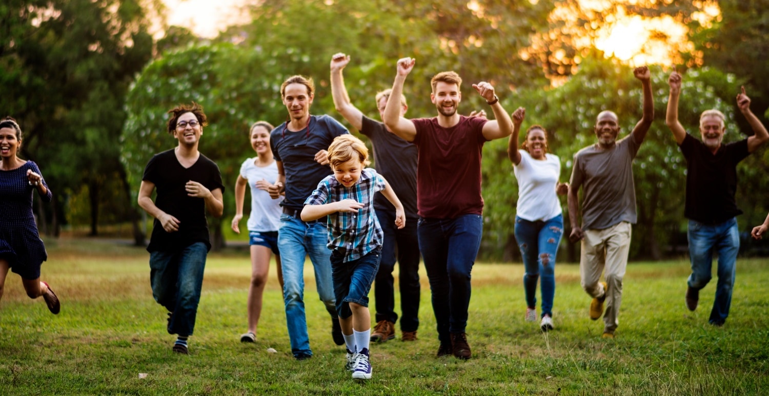 Group of people walking and running playful in the park