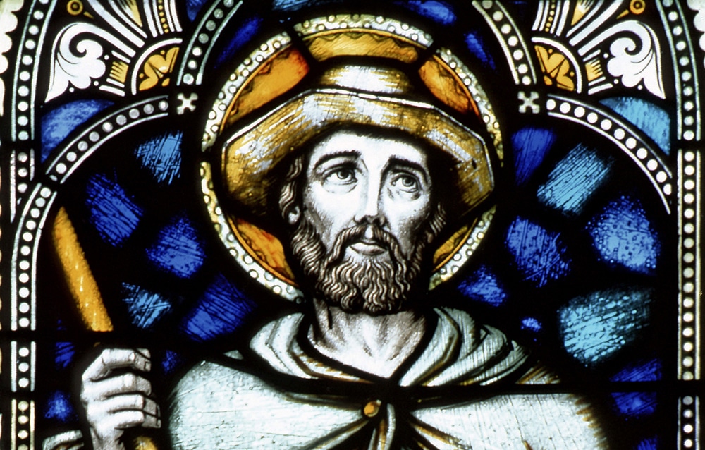 A stained glass image of Isidore the Farmer