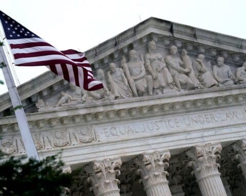 The American flag flies in front of the Supreme Court Building.