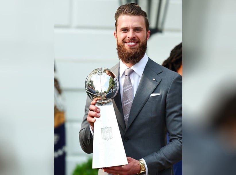 Kansas City Chiefs kicker Harrison Butker, wearing a pro-life tie and tie clip, holds the Super Bowl trophy during a visit to the White House.