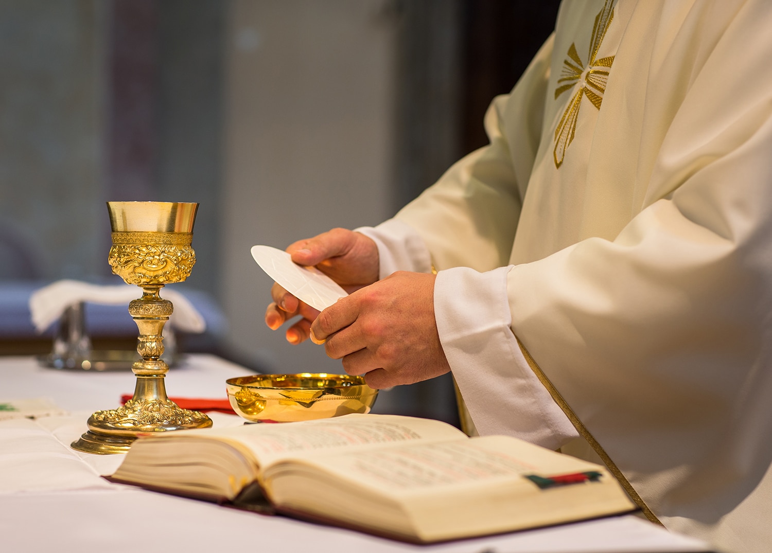 A priest's hands as he prepares Holy Communion