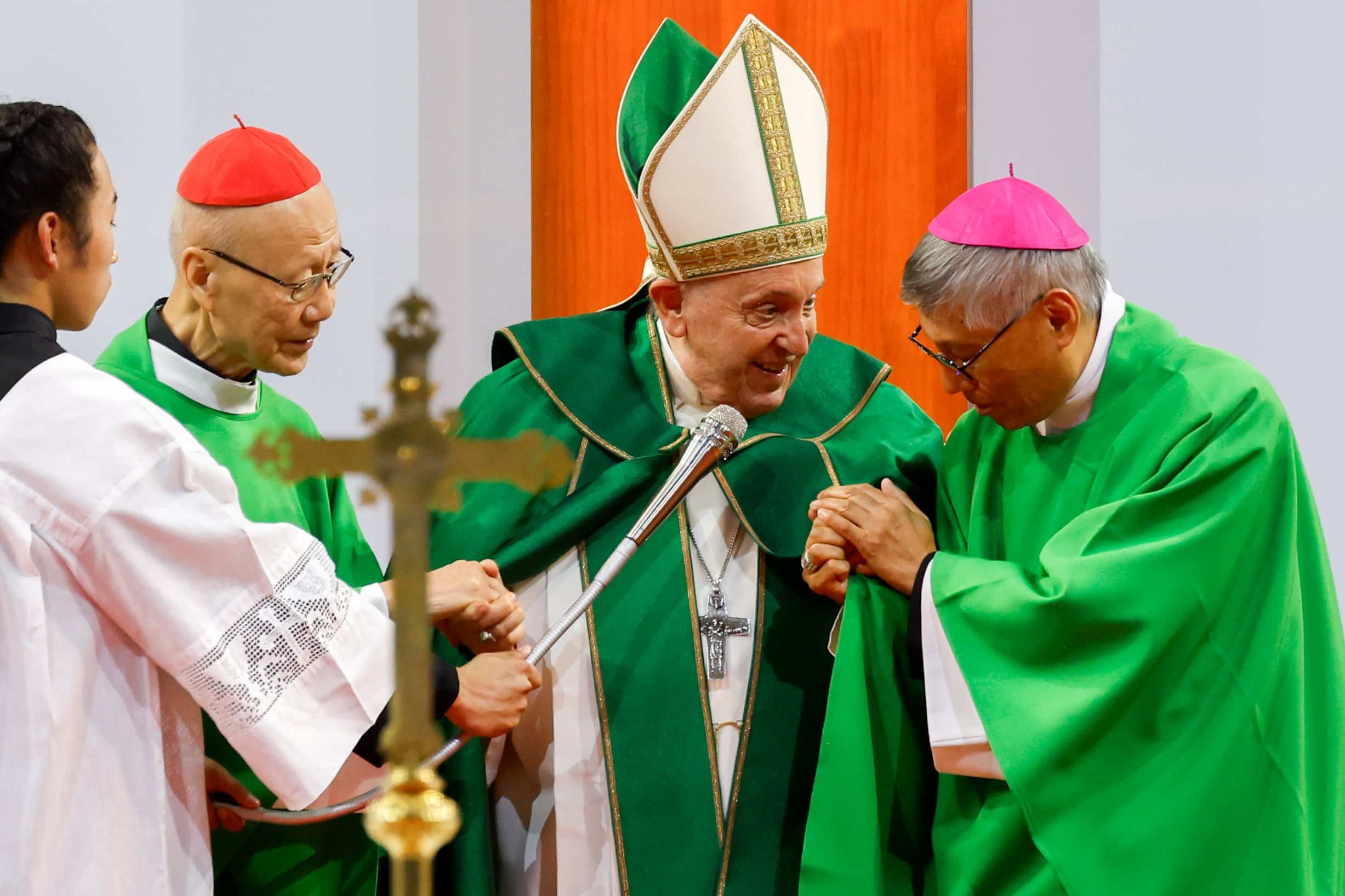 Pope Francis grasps the hands of retired Cardinal John Tong Hon of Hong Kong and Cardinal-designate Stephen Chow Sau-Yan of Hong Kong