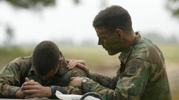 Chaplain Streucker praying with Soldier